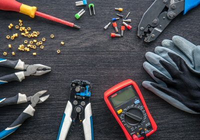 Flat lay composition with electrical tools on wooden background.